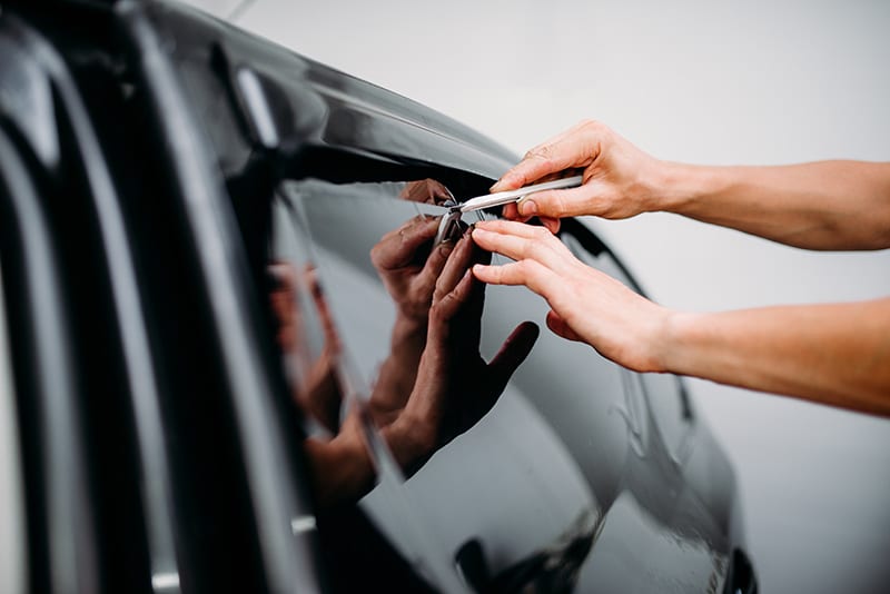 guy applying car window tint