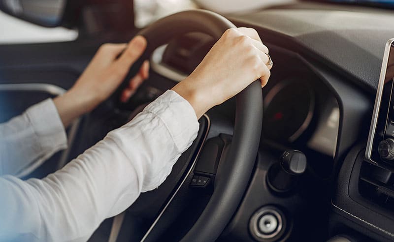 woman's hands on steering wheel