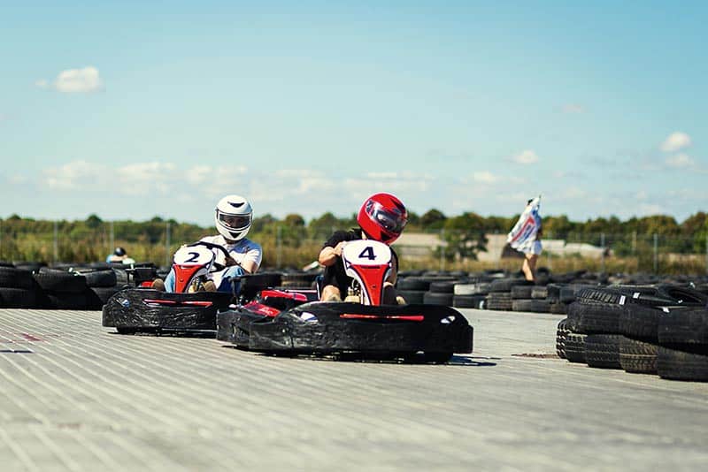 drivers take curve on go kart track