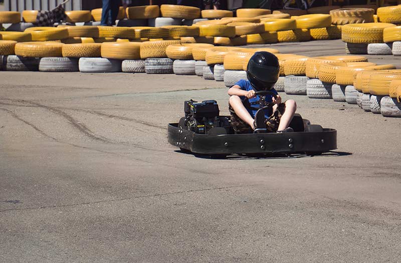 young driver drives go kart around track