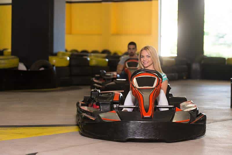 go kart drivers line up on indoor track